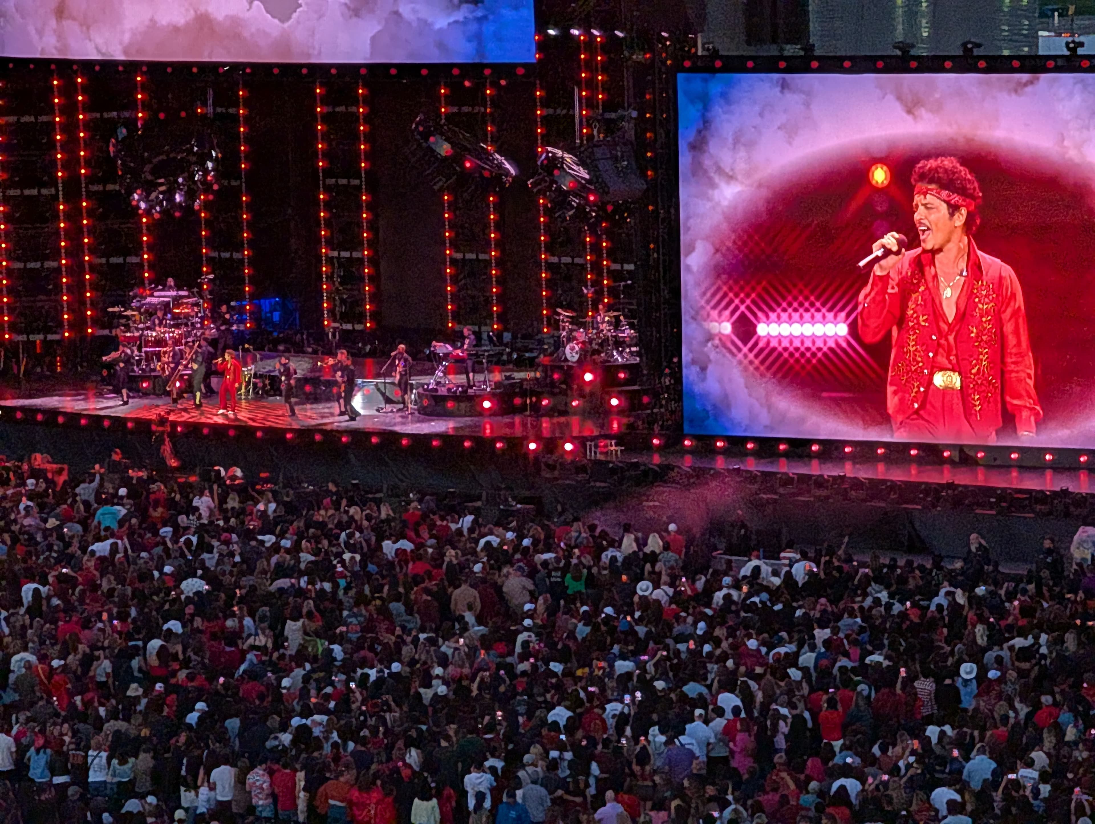A stadium concert crowd in front of a lit stage