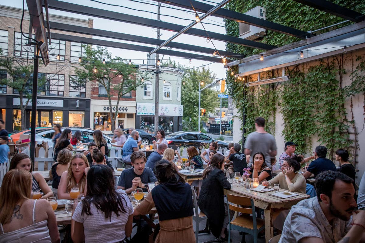 A full restaurant patio on Ossington at dusk
